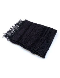 Folded hand-loomed recycled black fabric rug with fringe.