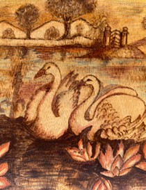Detailed view of intricate woodburned swan feathers and shading.