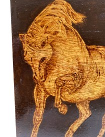 Detailed view of woodburned horse head and mane textures.