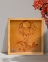 Framed woodburned art of a dolphin tied to balloons in a lifestyle setting.