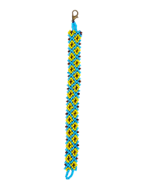 Flat lay of a long hand-stitched blue and yellow floral beaded bracelet with bronze clasp.