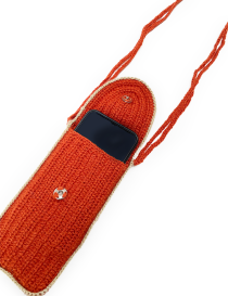 Open crochet pouch showing internal metal snap button and smartphone inside.
