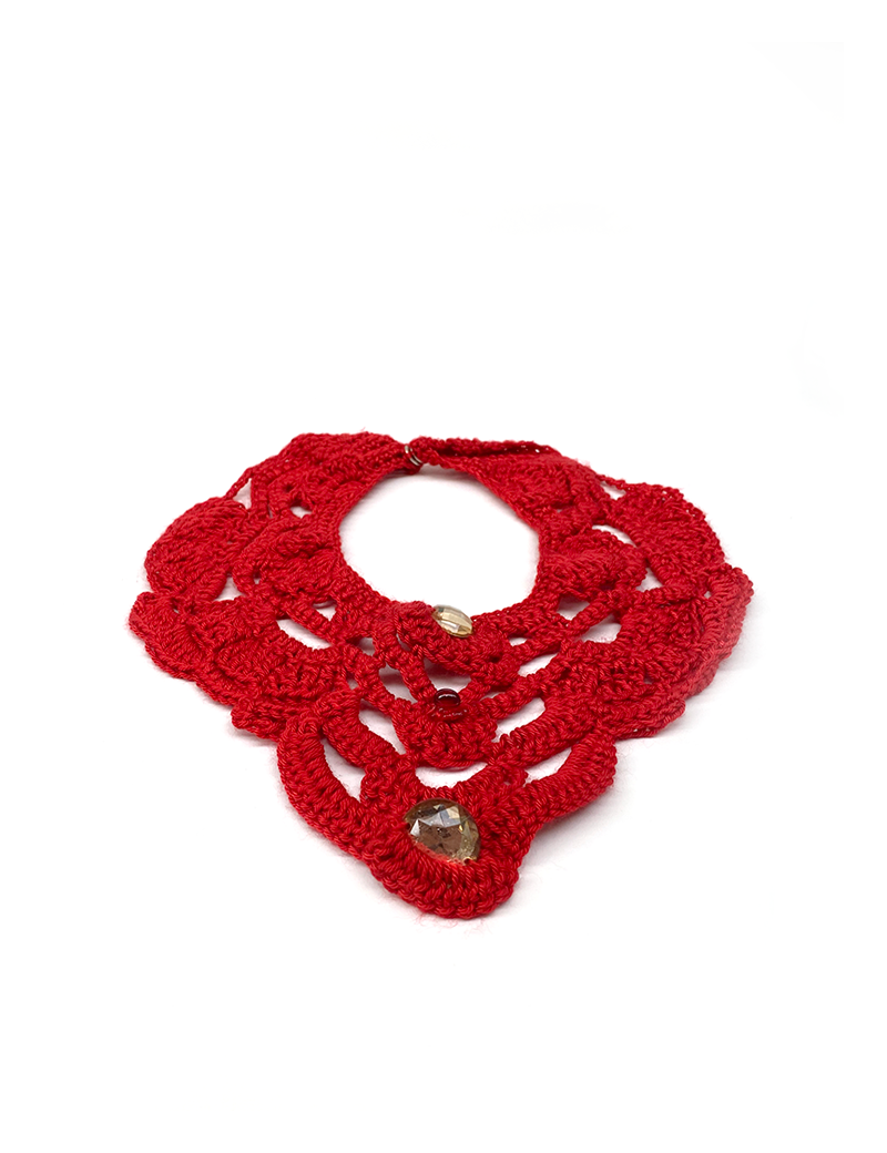 Flat lay of a dark red handmade crochet statement collar with decorative beads on a white background.