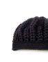 Close-up detail of the intricate popcorn and rib crochet stitches on a black winter hat.