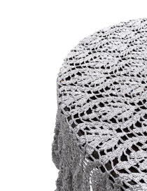 Side view of silver crochet lace draped over a table edge.