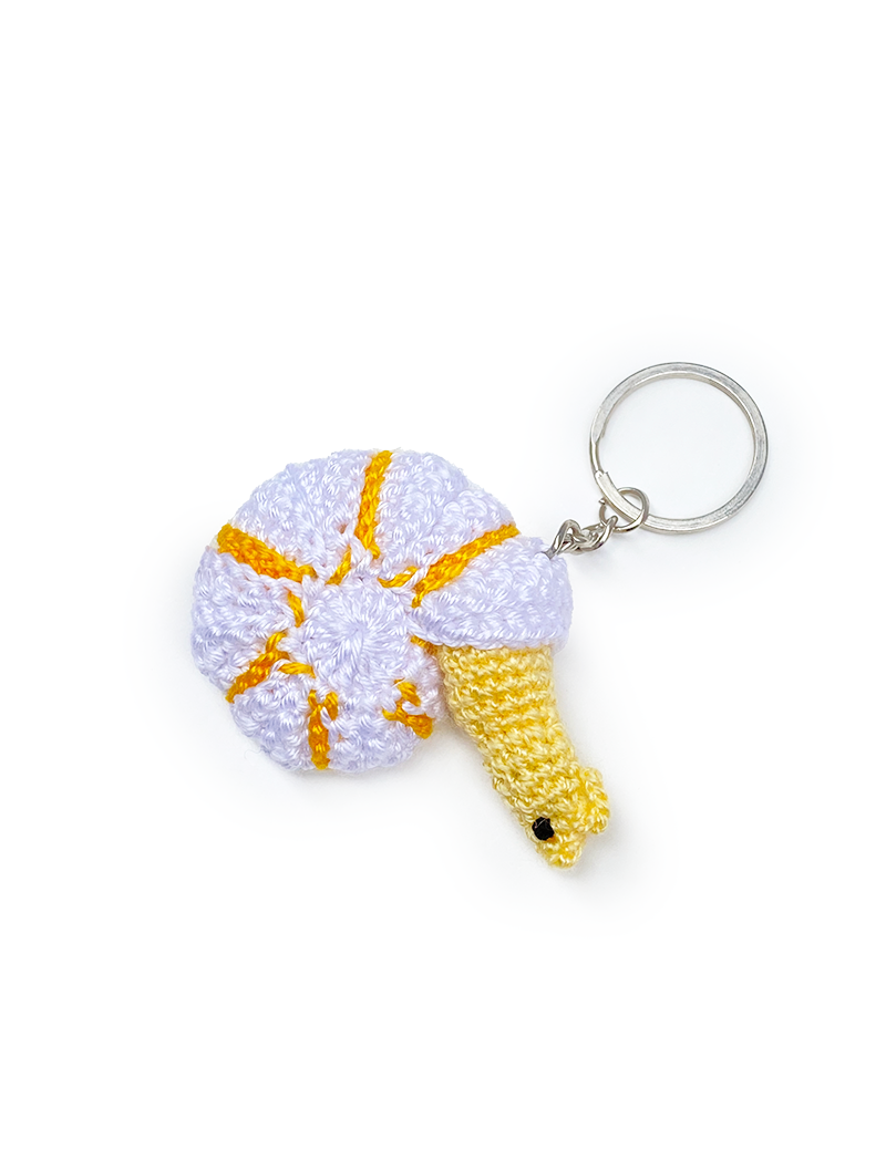 White crochet snail keychain with yellow spiral shell accents.