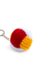 Full view of the red and yellow crochet puzzle ball keychain on a white background.