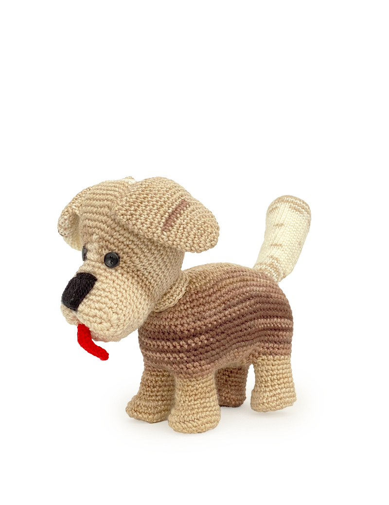 Three-quarter view of a handmade dog doll featuring its playful red yarn tongue.