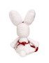 Back view of crochet bunny showing red apron tie and white pom-pom tail.
