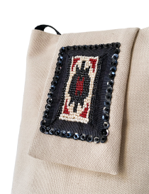 Close-up of handloomed twisted bead motif on black fabric base.