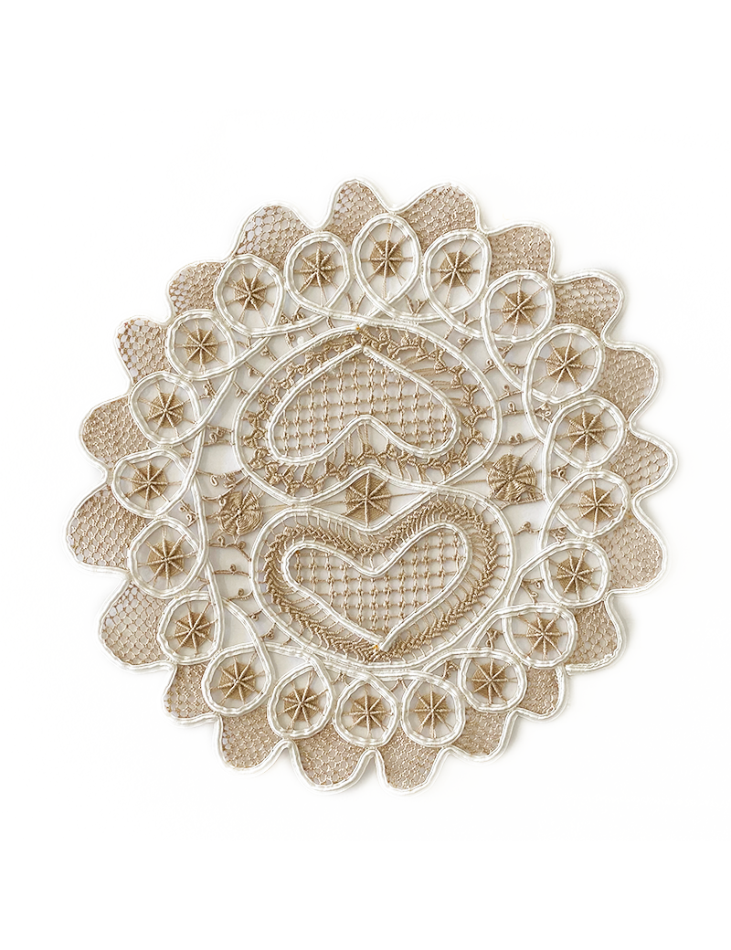 Overhead view of 28cm handmade lace doily with heart motif.