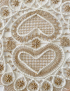 Close-up of beige cotton lace and white ribbon heart detail.