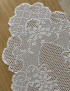 Close-up of floral lace patterns on white wood background