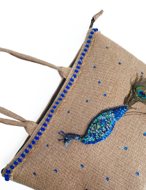 Detailed hand-beaded peacock embroidery with blue sequins on jute.
