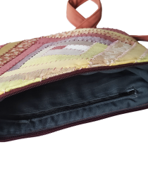Interior view of brown patchwork bag showing black lining and inner zipper pocket.