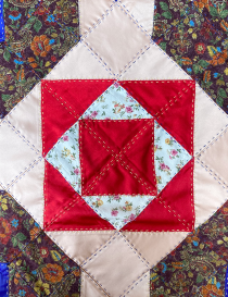 Central red and floral geometric star embroidery detail.