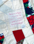 Reverse side of hand-stitched quilt showing artisan label and stitch work.