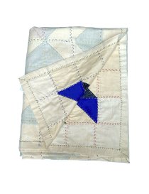 Folded handmade Syrian bedspread showcasing layers and lining.