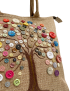 Close-up of handmade button tree embroidery on jute.