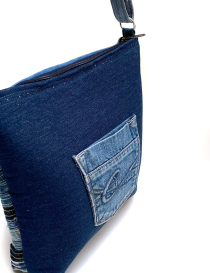 Angle view of the back pocket on the dark blue denim bag.