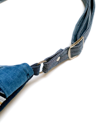 Close-up of the adjustable metal slider and denim strap hardware.