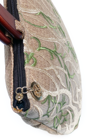 Close-up of top zipper and gold-tone Fazlakat logo charm.