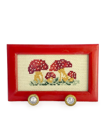 Front view of mushroom cross-stitch frame with red border and two crystal hooks.