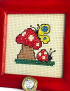 Detailed embroidery of red toadstool, ladybug, and yellow butterfly.