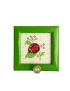 Front view of handmade ladybug cross-stitch embroidery in green frame with crystal hook.