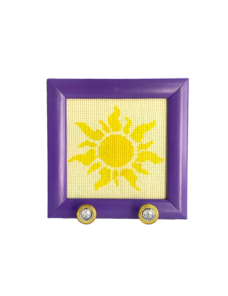 Purple square frame with yellow sun cross-stitch and two crystal hooks.