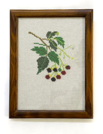Front view of blackberry branch cross-stitch embroidery in wooden frame.