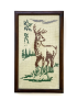 Front view of a framed handmade cross-stitch featuring a majestic deer and forest greenery.