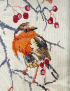 Close-up of handmade robin embroidery stitching details.