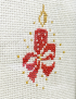 Close-up of red and gold embroidery stitches on cream-colored fabric.