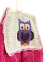 Detailed view of handmade owl cross-stitch and lace trim.