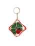Front view of handmade cross-stitch ladybug and shamrock keychain with red border.