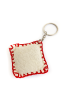 Back view showing the textured cream fabric and red hand-stitched edging of the keychain.