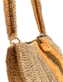 Close-up of gold-tone metal rings and the sturdy crochet strap of the shoulder bag.