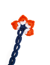 Close-up detail of the orange and white crochet flower petal stitching and blue chain.