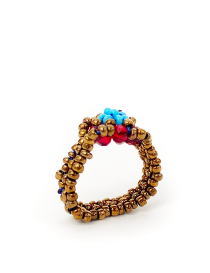 Side view of a handwoven beaded ring showing the intricate bronze threadwork and ruby crystal accents.