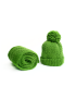 Rolled green handmade wool scarf next to matching winter hat gift set.