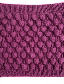 Detailed view of handmade pineapple knit pattern in mauve