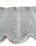 Close-up of Mufaragh stitch and silver Qasab sparkle on grey knit.