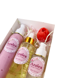 Close-up of Azalea Beauty Products labels on luxury pink and gold cosmetic bottles.