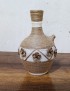 Handmade jute-wrapped clay vase with beige twine flowers.