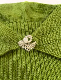 Girls' handmade green sleeveless knitted dress with textured skirt and swan brooch.