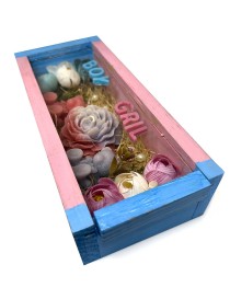 Crimson blue-pink wooden gift box with a "He or She?" candle and floral wax decorations for a baby gender reveal.