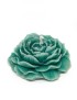 Detailed teal peony-shaped sculptural wax candle on a white background.