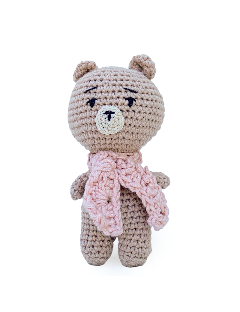 Hand-crocheted beige amigurumi teddy bear wearing a pink knit scarf.