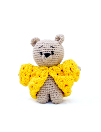Miniature handmade beige crochet teddy bear wearing a bright yellow textured sweater.